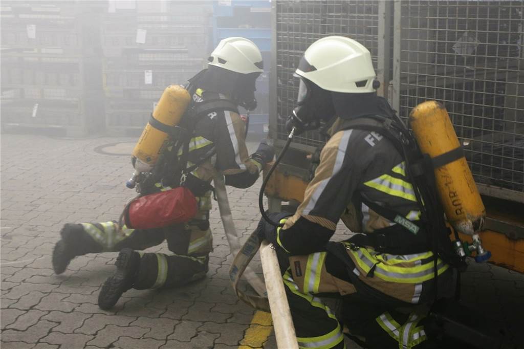 Mit Video: Lkw brennt, Menschen in Gefahr – knifflige Lage für Feuerwehrkräfte Durch den dichten Rauch war dem Trupp die Sicht in der Halle erschwert auf dem Weg zu Stapler und Lkw, wo zwei Vermisste vermutet wurden.