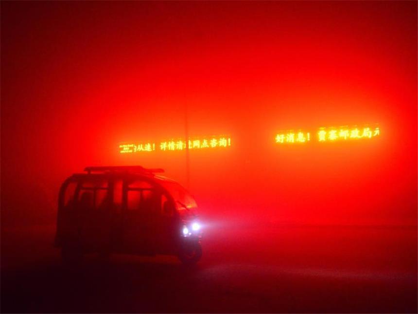Smog nimmt einer halben Milliarde Chinesen den Atem Durch den dichten Smog färbt eine Leuchtschrift das Straßenbild in der chinesischen Stadt Qingzh rot. Foto: Wang Jilin