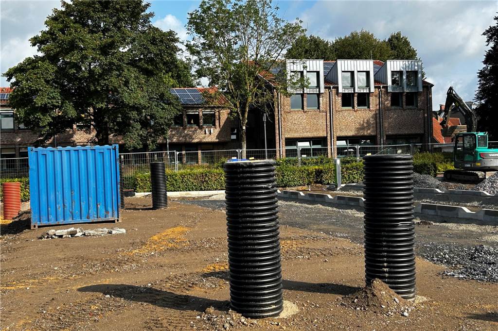Rathaus-Parkplatz in Raesfeld soll pünktlich fertig werden Schwarze Röhren ragen auf einer Baustelle aus der Erde.