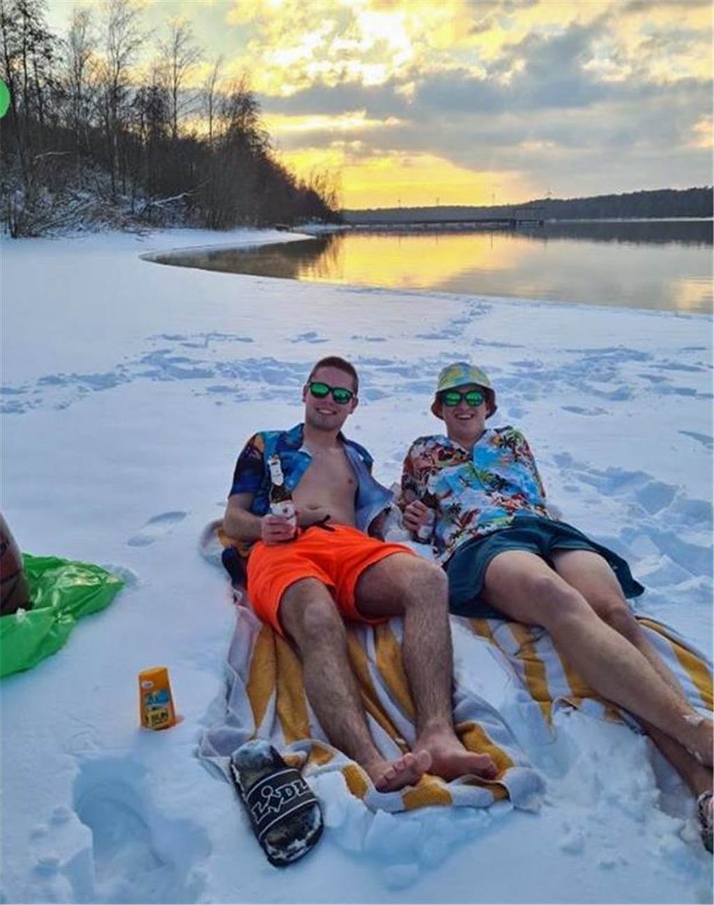 Zwei Männer liegen im Schnee. Sie tragen Sommerkleidung.