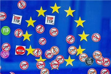 Dutzende Protest-Aufkleber auf einer Europa-Flagge am Gebäude der EU-Kommission in Brüssel. Verbraucherschützer warnen vor weiteren Handelsabkommen nach TTIP und Ceta. Foto: Stephanie Lecocq/Archiv