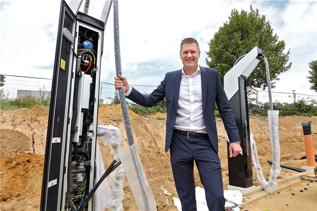 Porsche baut Auto-Tempel am Flughafen, der weltweit Vorbild sein soll E-Mobilität wird am neuen Standort groß geschrieben. Geschäftsführer Christoph Kösters zeigt hier eine der vier Schnellladesäulen, die vor dem neuen Porsche Zentrum Dortmund bereitstehen werden.