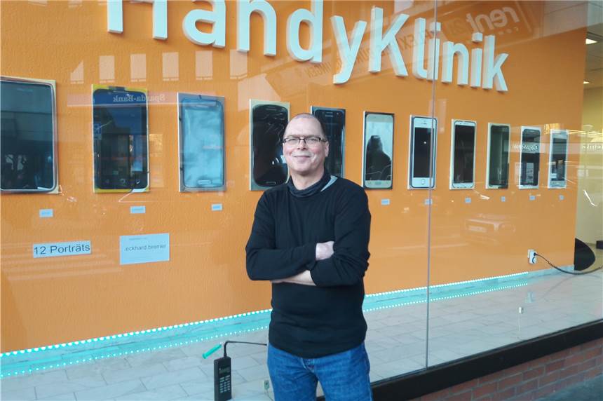 Eckard Bremer hat Handys gemalt und zeigt 12 Porträts der eigenwilligen Art Eckhard Bremer vor seinen Smartphone-„Porträts", die in der Handyklinik zu sehen sind.