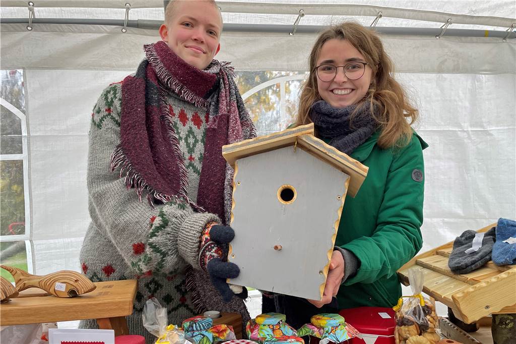 Edda Pfeffer (l.) und Antonia Jeismann präsentieren eine der Holzarbeiten ihres Opas Heinrich Döbbe. Der Erlös des Verkaufes an diesem Stand kommt der Kolpingsfamilie zugute.