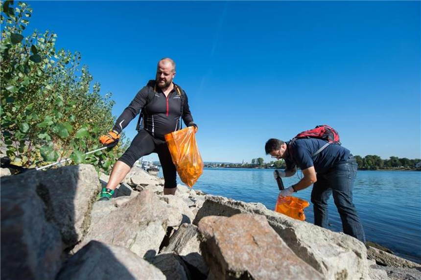 Ehrenamtliche sammeln bei der Umweltinitiative „Rhine Cleanup Day“ am Rheinufer in Mainz Müll. Foto: Silas Stein