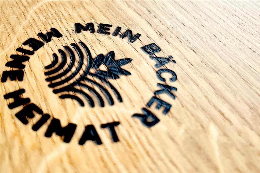 Bäckerei im Endspurt: Verweyen eröffnet Filiale an der Fuistingstraße Der Brandstempel "Mein Bäcker, meine Heimat" auf einem der Tische in der neuen Filiale