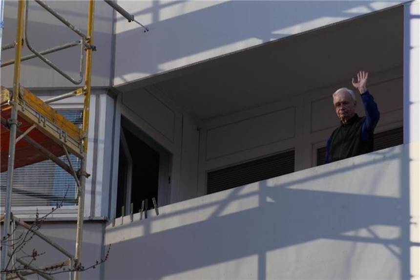 Ein älterer Mann winkt von einem eingerüsteten Balkon in einer Szene aus der ZDF-Reportage "Teurer Wohnen". Foto: Ken Kabelitz