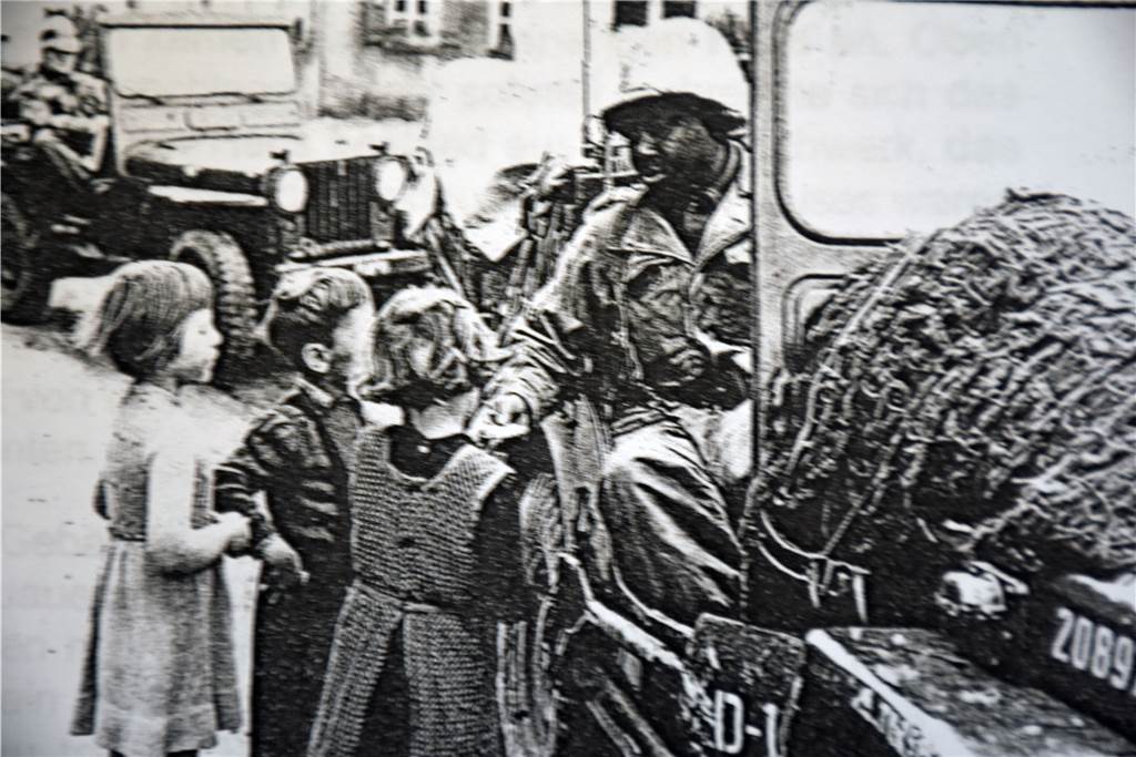 Als der Hahn von St. Vitus von einer Artillerie-Granate getroffen wurde Ein amerikanischer Soldat verteilt in Olfen Süßigkeiten an Kinder.
