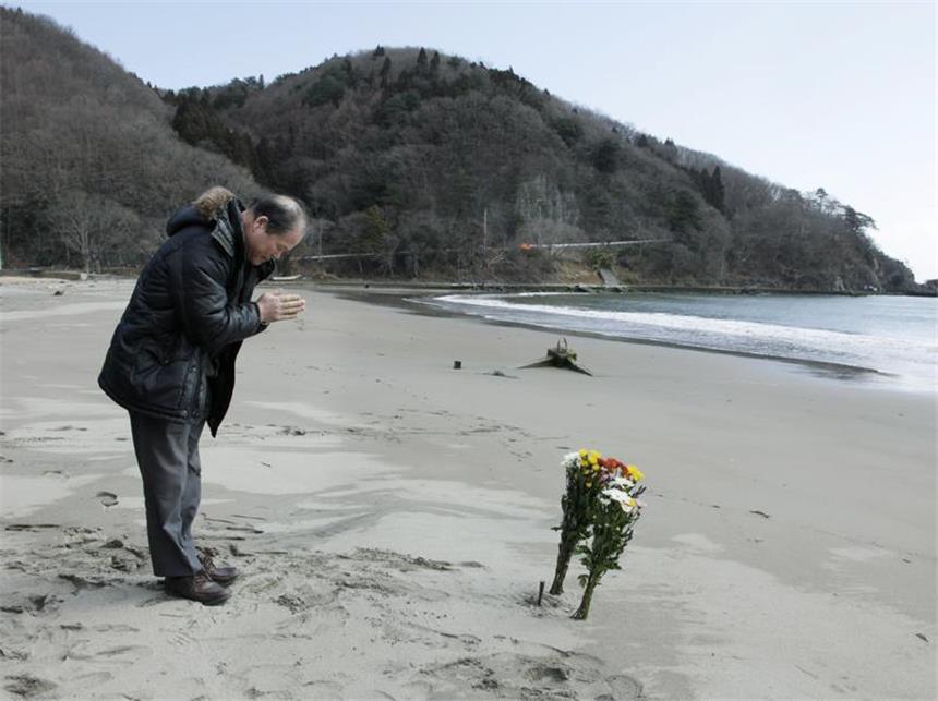 Japan und die Welt gedenken der Tsunami- und Atomtod-Opfer Ein Angehöriger trauert am Strand um seine Familie, die beim Tsunami ums Leben gekommen war. Foto: Kimimasa Mayama