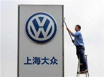 Ein Arbeiter reinigt das Firmenschild eines Volkswagen Autohauses in der Nähe von Schanghai.
