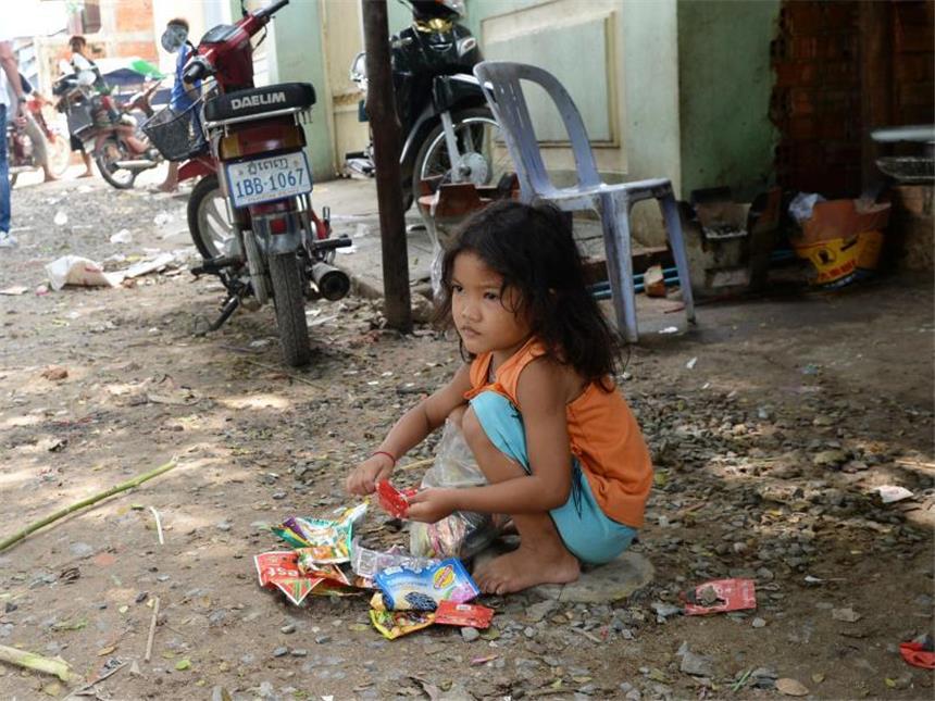 Millionen Kinder sterben durch Dreck und Hygienemangel Ein armes Mädchen spielt in Phnom Penh mit Müll. Foto: Jens Kalaene