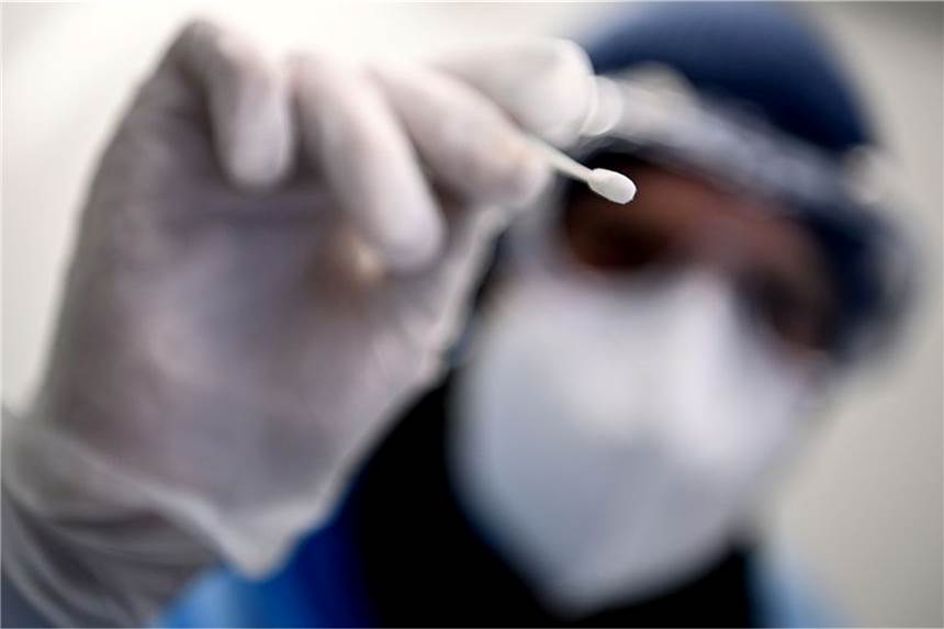 Ist auf Corona-Testergebnisse noch Verlass? Ein Arzt beim Gesundheitsamt Neukölln hält ein Teststäbchen für einen PCR-Test in der Hand.