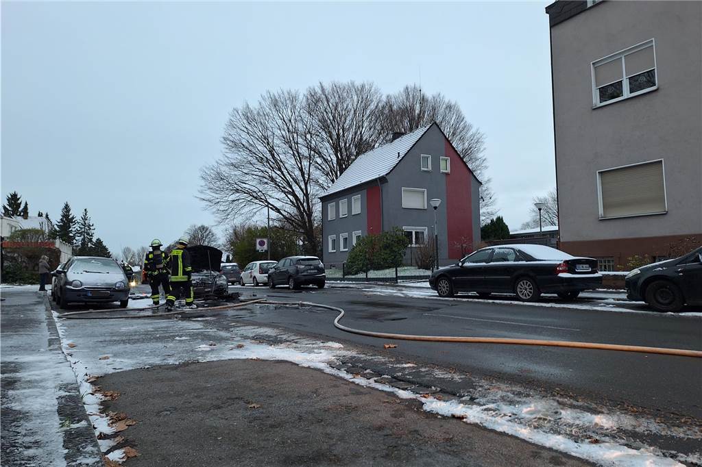 Drei brennende Autos blockierten Berufsverkehr in Lütgendortmund Zwei Einsatzkräfte der Feuerwehr stehen neben einem Auto in der Westricher Straße in Lütgendortmund, das am Montagmorgen (4.12.) Feuer fing.