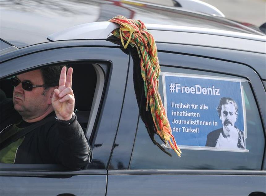 U-Haft für Türkei-Korrespondent "unverhältnismäßig" Ein Autokorso-Teilnehmer hat ein Plakat «#Free Deniz» am 25.02.2017 in Flörsheim (Hessen) auf der Seitenscheibe und macht dabei das Victory-Zeichen.