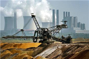 Ein Bagger fährt vor der Kulisse des RWE-Kraftwerkes Niederaußem durch den Tagebau Garzweiler. Foto: Oliver Berg/Archiv
