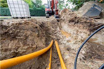 Ein Bagger hebt Erdreich für die Verlegung von Breitband-Kabeln aus. Foto: Guido Kirchner