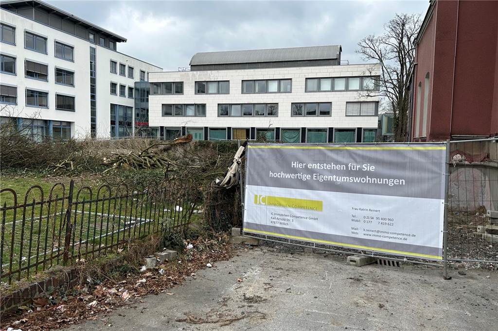 Neubau neben roter Ziegelvilla mit 22 Eigentumswohnungen in der City Ein Banner der Immobilienfirma auf dem Grundstück.