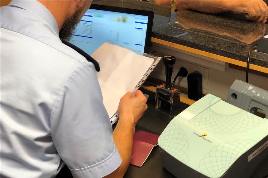 Abgelehnter Asylbewerber versucht zweimal mit fremden Dokumenten auszureisen Ein Beamter der Bundespolizei prüft nach der Ankunft einer WizzAir-Maschine ein Reisedokument eines Passagiers. (Symbolbild)