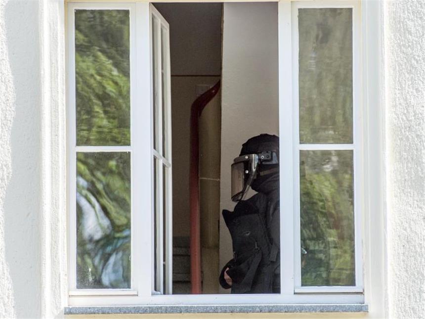 Polizei: Mann aus Eisenhüttenstadt ist IS-Sympathisant Ein Beamter des Spezialeinsatzkommando ist im Haus des Verdächtigen. Foto: Patrick Pleul