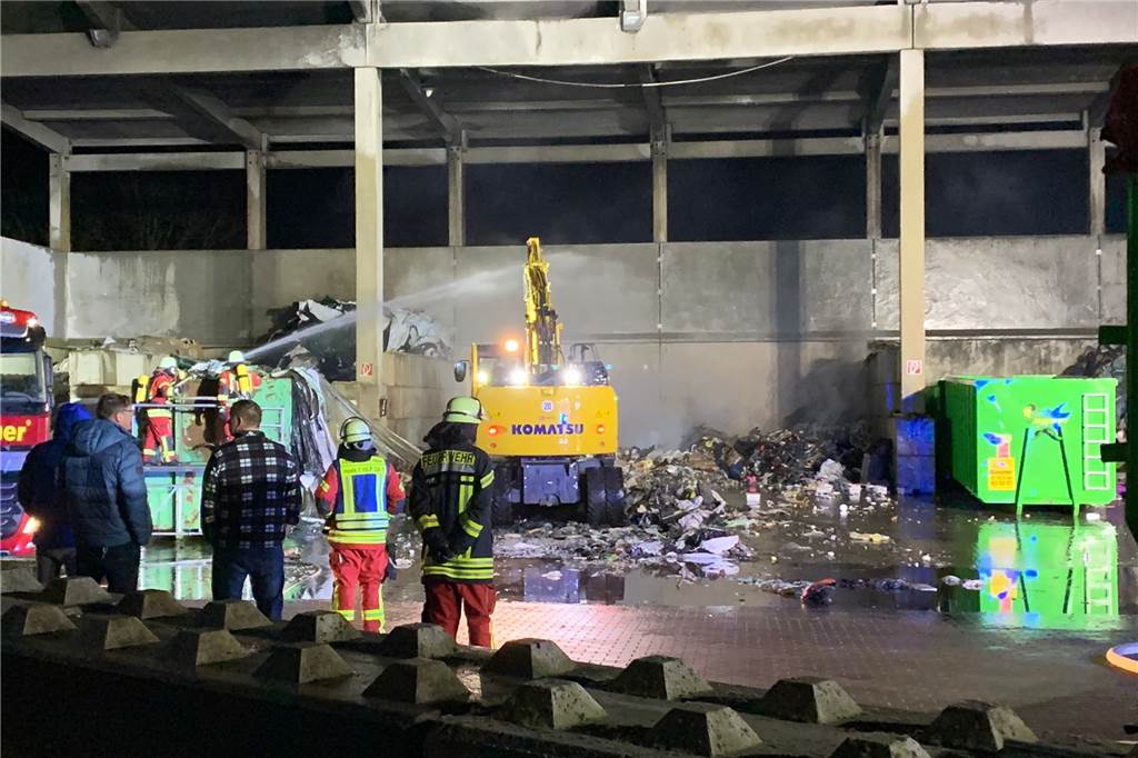 Ein benachbartes Unternehmen stellte der Feuerwehr einen Bagger zur Verfügung, mit dem der abgelöschte Abfall auseinander und aus der Halle gezogen wurden.