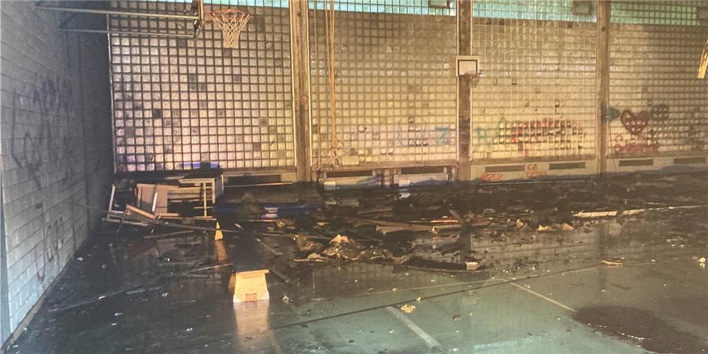 Gefahr für Feuerwehrleute bei Löscharbeiten an der Turnhalle in Lünen Ein Blick durch die Tür in die Sporthalle in Lünen-Wethmar: An mehreren Stellen gibt es Spuren von Feuer in der seit Jahren verwaisten Halle.