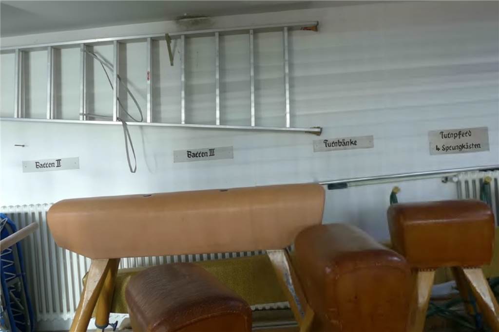 Ein Blick in den Geräteraum der Turnhalle: Auch die Art der Beschriftung zeigt, dass die Räumlichkeiten aus einer anderen Zeit stammen.
