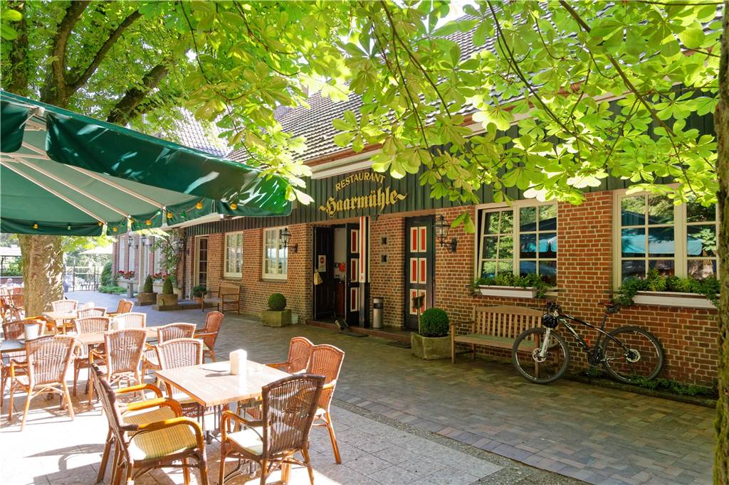 Die Haarmühle bietet rustikale Sattmacher in einem einzigartigen Ambiente Ein Blick von außen auf den Biergarten und das Gebäude des Landgasthofs Haarmühle