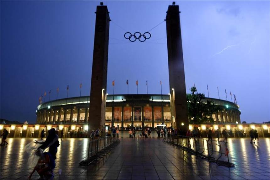 Ein Blitz (r) erhellt den Himmel über dem Olympiastadion. Foto: Bernd Thissen
