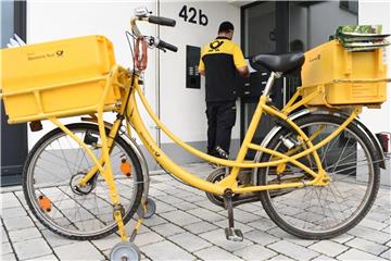 Ein Briefträger der Deutschen Post verrichtet in Frankfurt am Main seine Arbeit. Foto: Arne Dedert