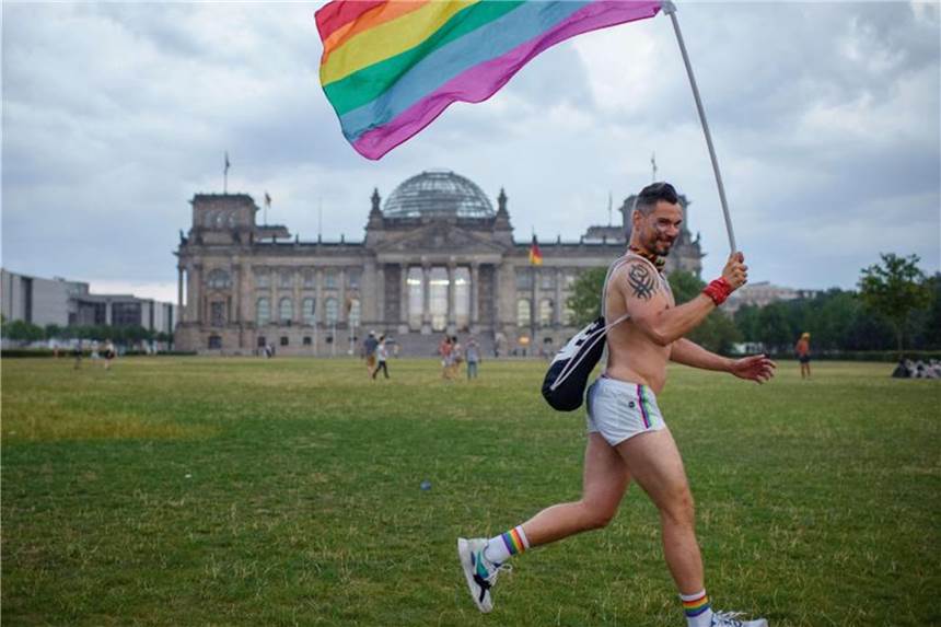 Zehntausende feiern beim verkürtzen Berliner CSD Ein CSD-Teilnehmer läuft nach Abbruch der Parade wegen Unwetter am Reichstag vorbei. Foto: Gregor Fischer