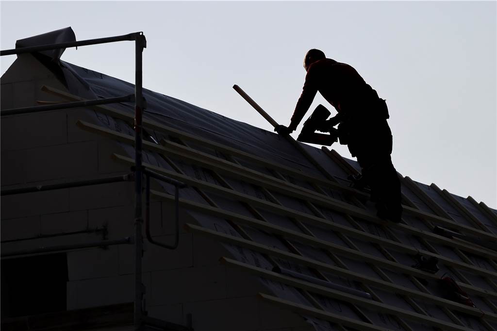 Baugrundstücke : Stadtlohn macht 2023 einen Schnitt in der Bewerberliste Ein Dachdecker auf dem Dach eines Einfamilienhauses (Symbolbild).