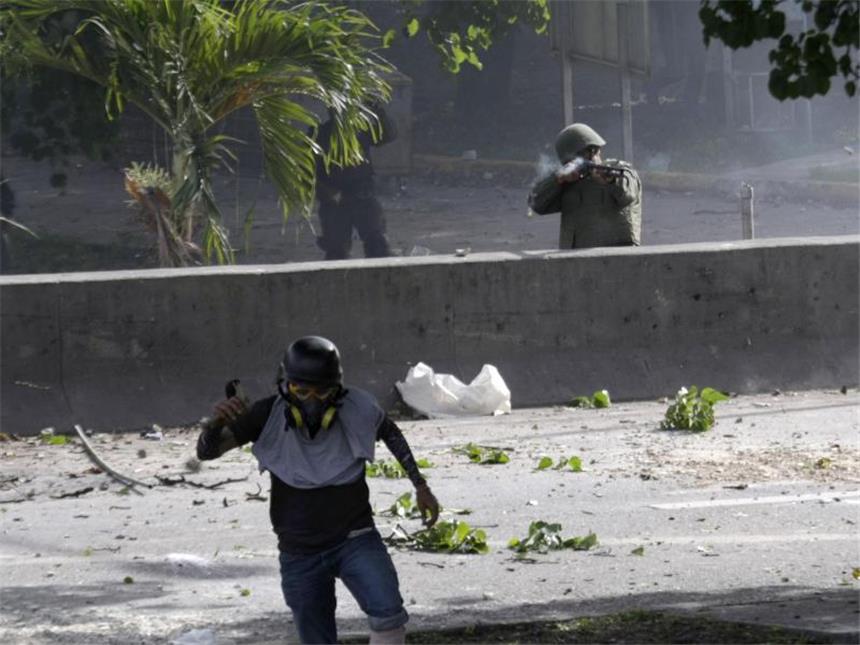 Blutige Proteste gegen die Regierung in Venezuela Ein Demonstrant flieht vor Schüssen. Foto: Fernando Llano