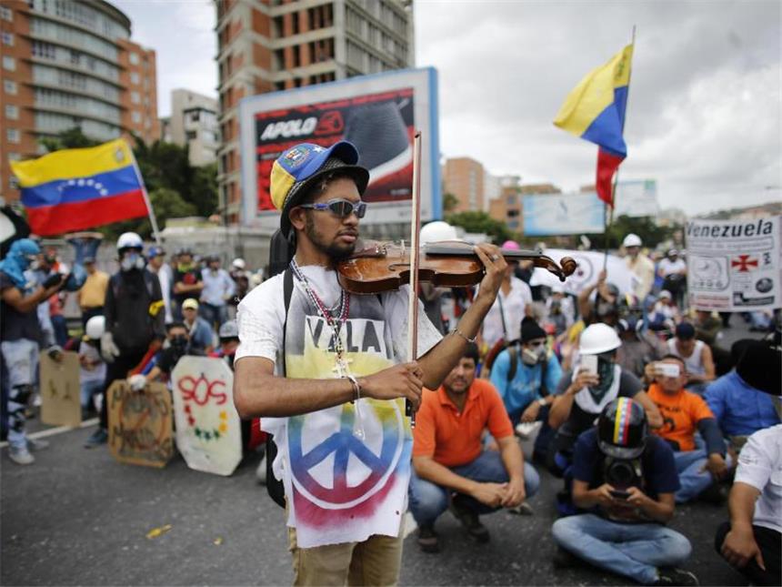 Blutige Proteste gegen die Regierung in Venezuela Ein Demonstrant spielt Geige. Foto: Ariana Cubillos