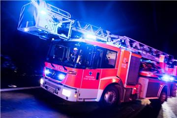 Ein Drehleiterwagen der Feuerwehr fährt mit Blaulicht über eine Straße. Foto: Marcel Kusch/Archiv