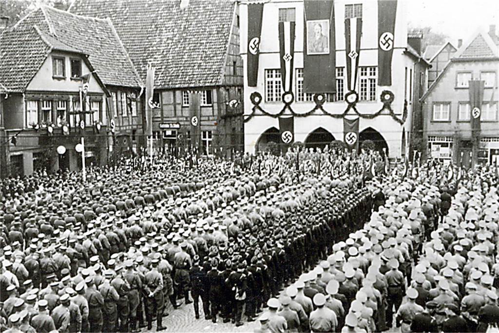 Ein dunkles Kapitel deutscher Geschichte. In der Zeit des Nationalsozialismus marschierte unter anderem die SA auf dem Werner Marktplatz auf. An der Rathausfassade hängt ein Portrait Adolf Hitlers.