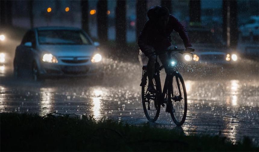 Sommergewitter ernsthafte Gefahr für Haus und Auto Ein Fahrradfahrer und Autos fahren am 19.07.2017 bei einem Unwetter mit Starkregen auf einer Straße in Hannover (Niedersachsen). Foto: Silas Stein/dpa +++(c) dpa - Bildfunk+++