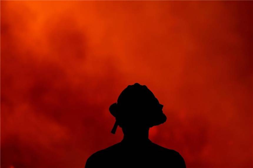 Ein Feuerwehrmann beobachtet das „Holy Fire“ im Cleveland National Forest. 18 Waldbrände lodern derzeit im US-Bundesstaat Kalifornien. Foto: Ringo H.W. Chiu/AP