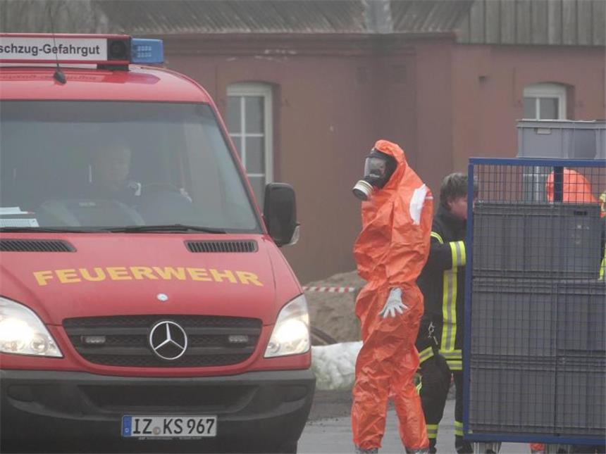 Neues Vogelgrippe-Virus H5N5 nachgewiesen Ein Feuerwehrmann im Schutzanzug steht in der Nähe von Steinburg vor einer Geflügelzucht. Foto: Carsten Rehder