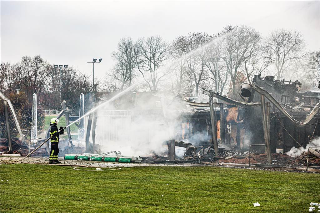 Brand in Golfclub: Polizei geht von Brandstiftung aus Ein Feuerwehrmann löscht den Brand auf dem Gelände eines Golfclubs in Dortmund.