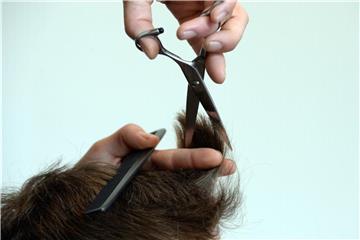Ein Friseur schneidet einem Mann die Haare. Foto: Susann Prautsch/Archiv
