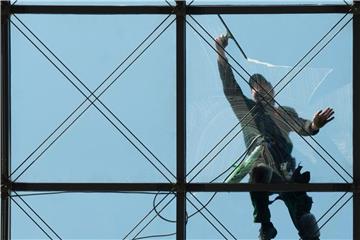 Ein Gebäudereiniger putzt ein gläsernes Dach. Die Wachstumseffekte des Mindestlohns seien auch deshalb so positiv, weil die Beschäftigung weitgehend stabil bleibe, sagen Forscher. Foto: Sebastian Kahnert