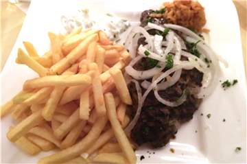 Ein griechischer Klassiker kommt bei Poseidon auf den Teller: Bifteki mit Pommes.