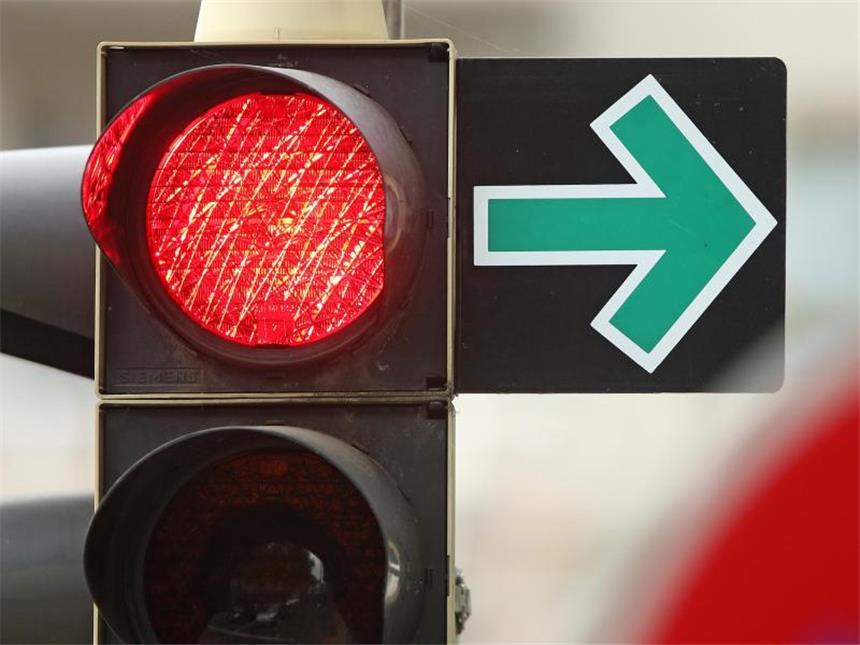 Was regelt der Grüne Pfeil an Einmündungen und Kreuzungen? Ein grüner Pfeil erlaubt das Abbiegen trotz roter Ampel an einer Kreuzung. Foto: Jan Woitas/dpa