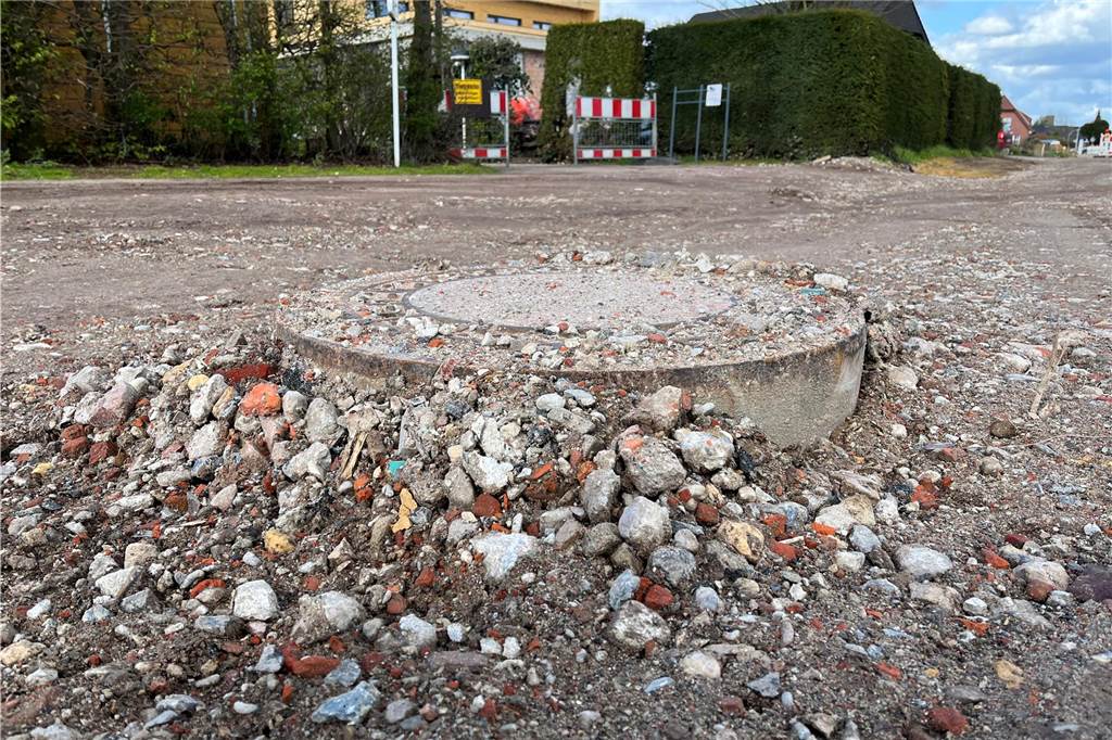 Ärger an der Pirolstraße: Anwohner erreichen Grundstücke nur schwer Ein Gulli ragt weit aus dem Schotter heraus.