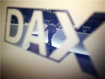 Ein Händler geht über das Parkett in der Börse in Frankfurt am Main und spiegelt sich dabei in einem Logo des Deutschen Aktienindexes (Dax). Foto: Fredrik von Erichsen