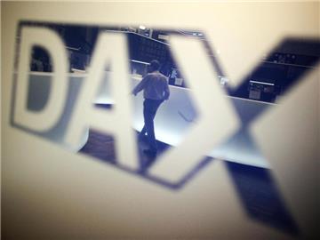 Ein Händler geht über das Parkett in der Börse in Frankfurt am Main und spiegelt sich dabei in einem Logo des Deutschen Aktienindexes (DAX). Foto: Fredrik von Erichsen