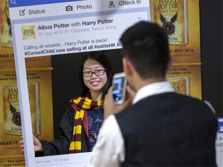Harry-Potter-Theater und Skriptbuch begeistern Fans Ein Harry Potter-Fan posiert in Hong Kong für ein Foto mit dem neu erschienenen Buch «Harry Potter and the Cursed Child». Foto: Jerome Favre