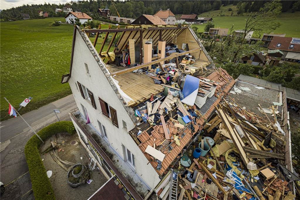 Sommer der Extreme bestätigt Klimaforscher Ein Haus mit abgerissenem Dach, nachdem ein Tornado durch die Stadt La Chaux-de-Fonds in der Schweiz gefegt ist.