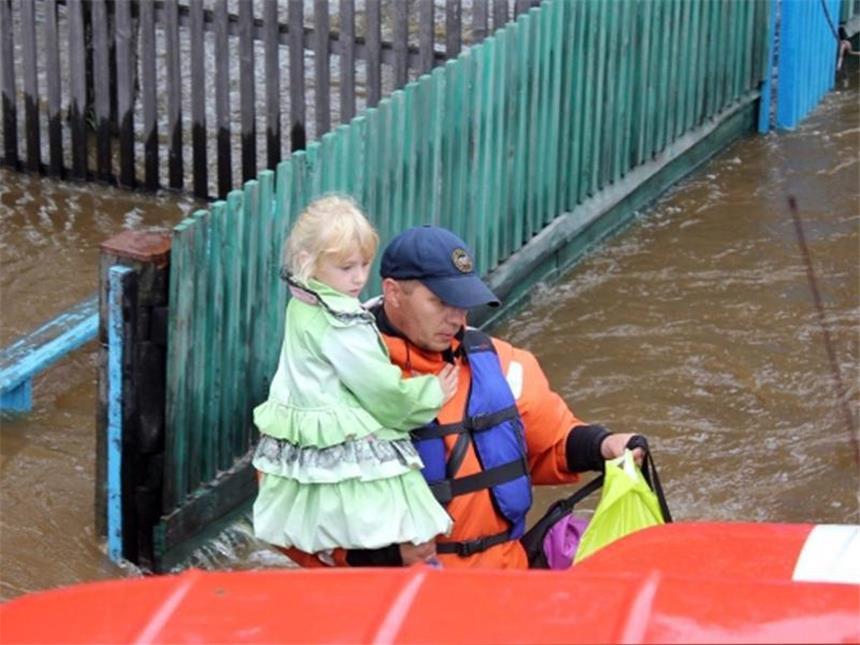 Fluten in China und Russland steigen weiter Ein Helfer trägt im Osten Russlands ein kleines Mädchen aus der Gefahrenzone. Foto: Russian Emergency Ministry Press Service
