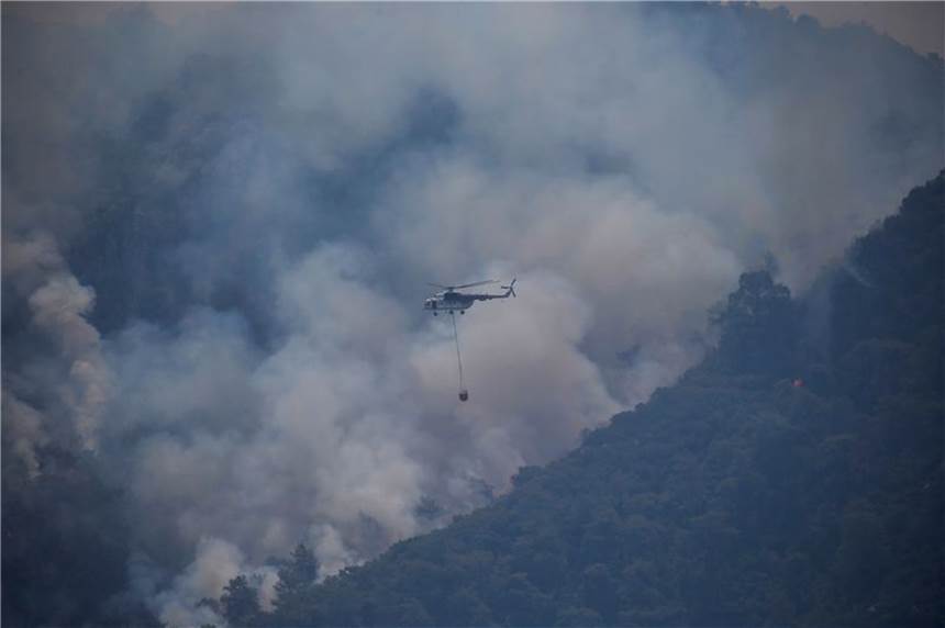 Feuer wüten in Mittelmeerländern - Weiter hohe Brandgefahr Ein Hubschrauber transportiert Löschwasser, um einen Waldbrand in der Türkei zu löschen.